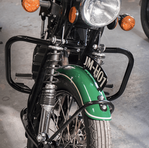Classic green motorcycle front view showing headlight and suspension.