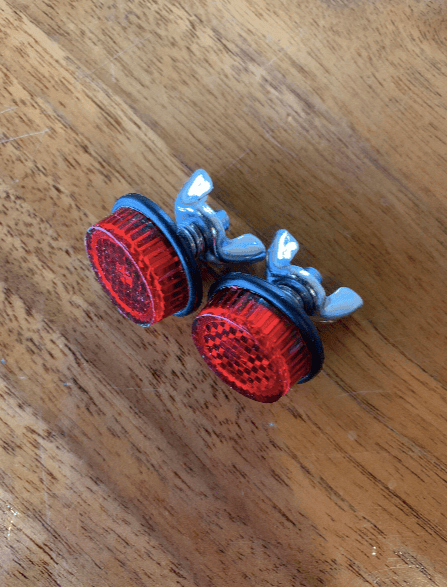 Red bicycle reflectors on a wooden surface.