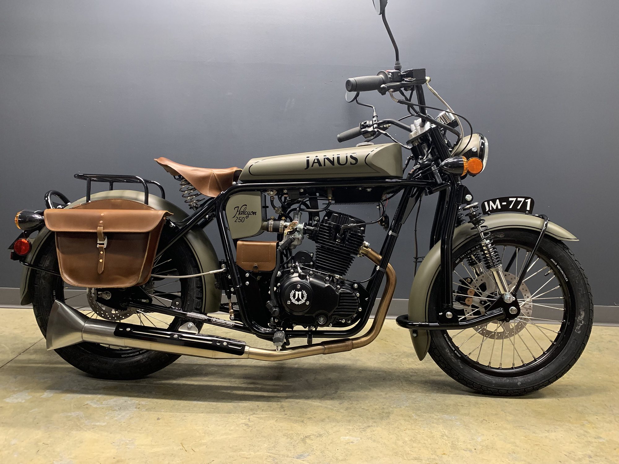 Vintage Janus motorcycle with sidecar and leather accessories on display.